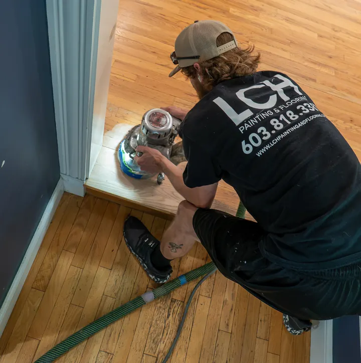 Brad Lyman of LCH edging along the wall of a hardwood floor in Nashua, NH