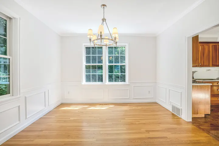 The same Bedford, NH dining room after LCH painted the walls a soft white, with the oak floor left as it was