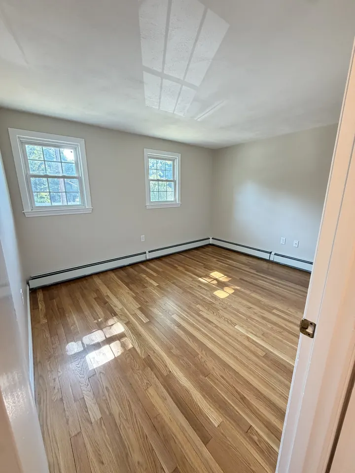 The same Manchester, NH bedroom after LCH sanded and refinished the hardwood floor in a satin finish