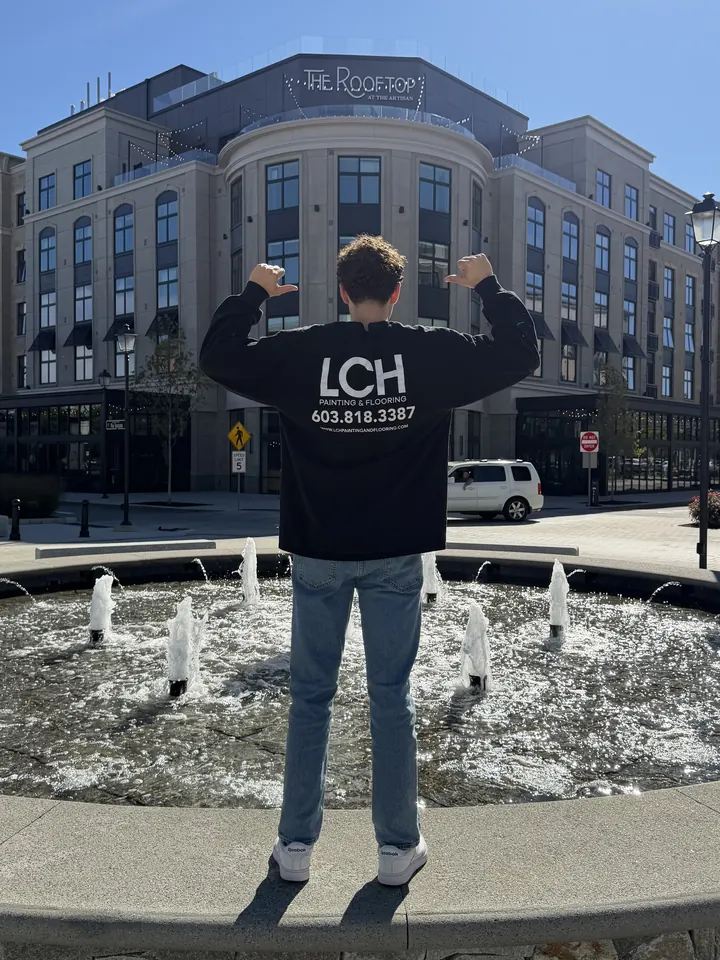 LCH crew member in an LCH shirt standing at the fountain at Tuscan Village in Salem, NH