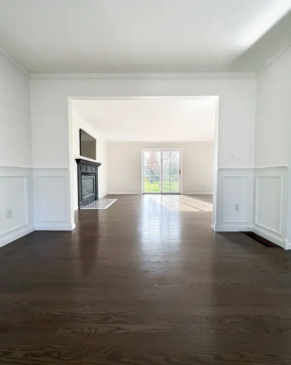 Dining room with dark stained hardwood floors and white wainscoting