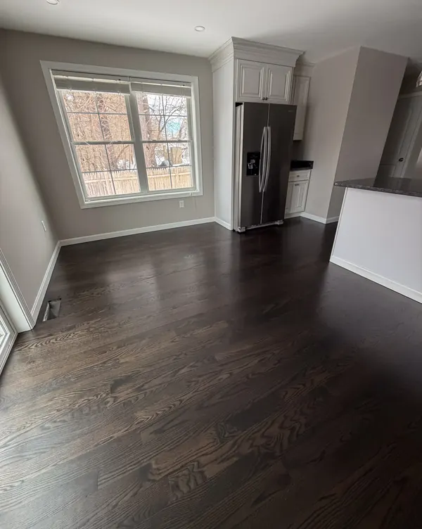 Kitchen and dining area with dark stained hardwood flooring